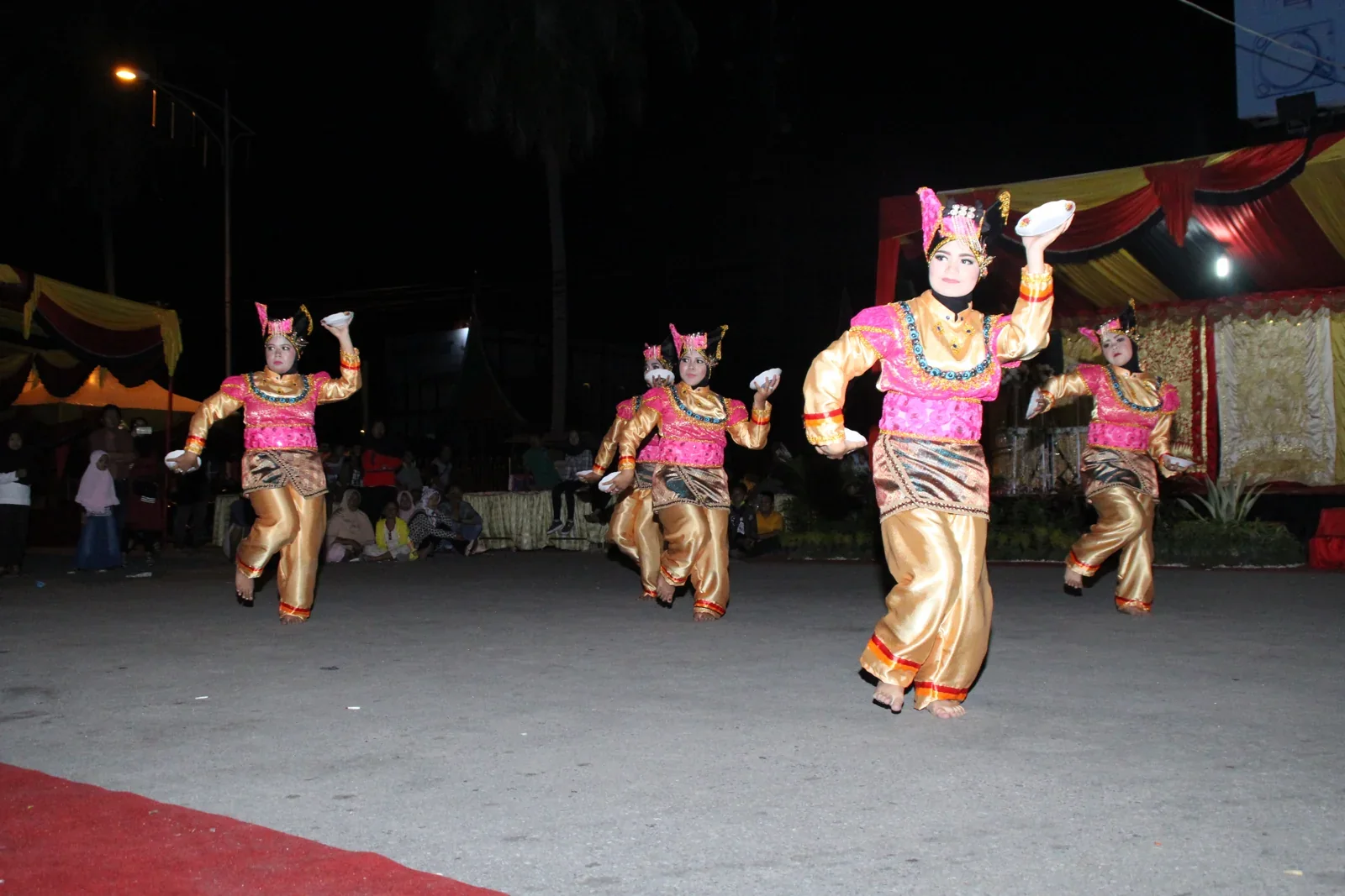 Penari Tari Piriang melangkah sambil membawa piring di kedua tangan
